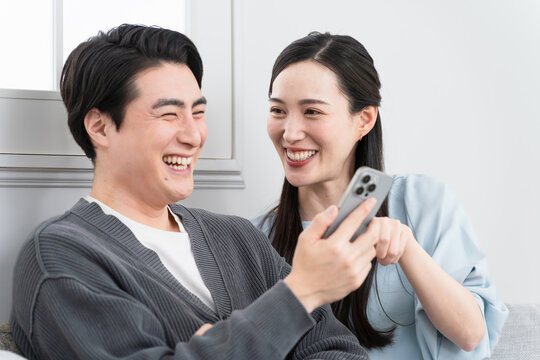 スマートフォンで検索をする若い男女　ライフスタイルイメージ