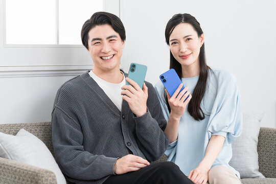 スマートフォンで検索をする若い男女　ライフスタイルイメージ