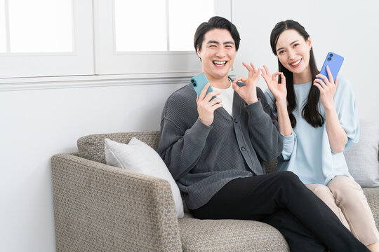 スマートフォンで検索をする若い男女　ライフスタイルイメージ