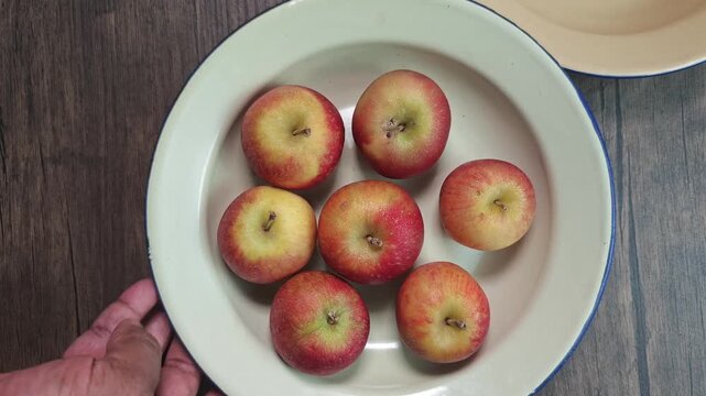 Red apple pink peach fruit whole sliced half seed tin plate chopping board wooded background