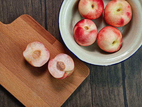 Red apple pink peach fruit whole sliced half seed tin plate chopping board wooded background
