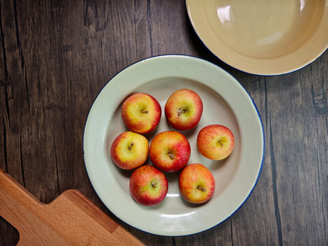 Red apple pink peach fruit whole sliced half seed tin plate chopping board wooded background