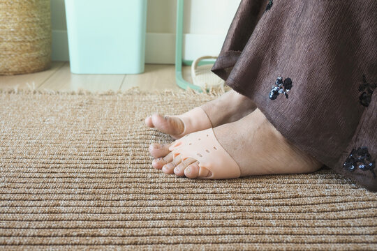 Person sits on floor with silicone five-finger foot alignment