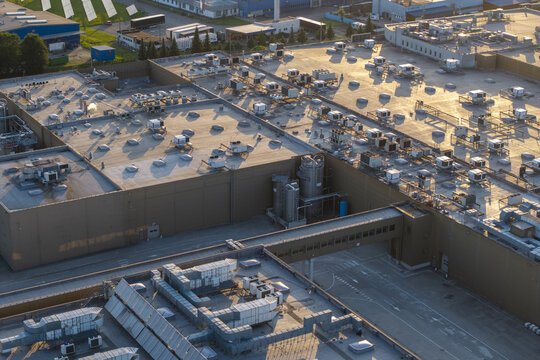 Dobczyce, Poland - 22 July 2026: Aerial view of the Wawel SA production facility featuring industrial rooftops, ventilation units, and metal silos under warm golden hour light.