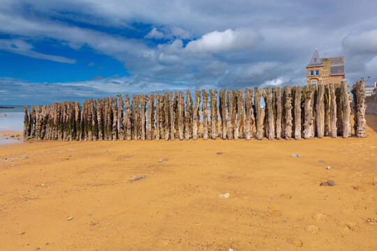 Traditional Wooden Wave Breakers on Sandy Beach at Low Tide in Saint Malo France