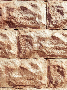 Textured sandstone brick wall with weathered surface pattern