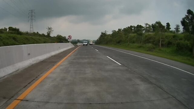 Rear Dashcam Driving Uphill on Purwodadi Toll Road with Vehicle Moving Away Ahead in East Java, Indonesia