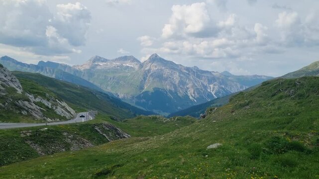 Panoramic view from Spl&uuml;gen Pass on the Swiss-Italian border, revealing Graub&uuml;nden&rsquo;s rugged Alpine peaks, high-altitude terrain, and lush green meadows in breathtaking mountain scenery