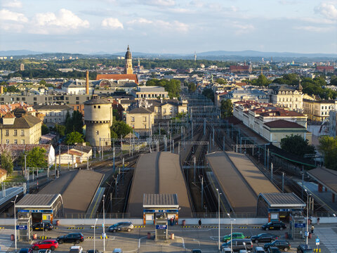 Krakow, Poland - 20 July 2026: Aerial view of the railway station platforms and tracks with the historic Stare Miasto skyline in the background under a clear blue sky.