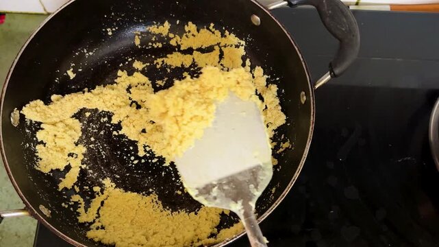 Roasting Semolina In Pan While Preparing Traditional Indian Suji Halwa At Home