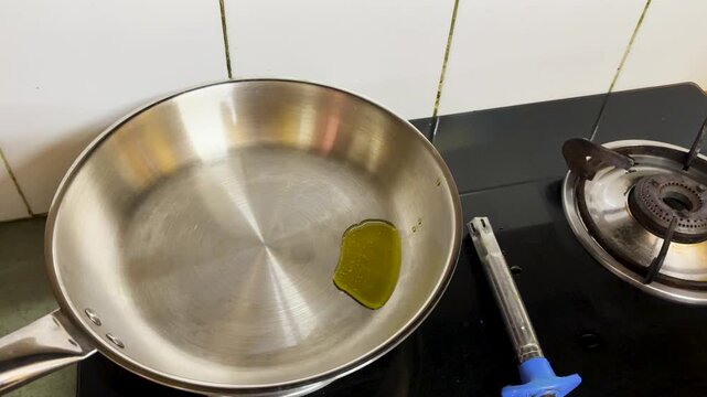 Pouring Cooking mustered oil Into Stainless Steel Pan For Traditional Indian Recipe Preparation