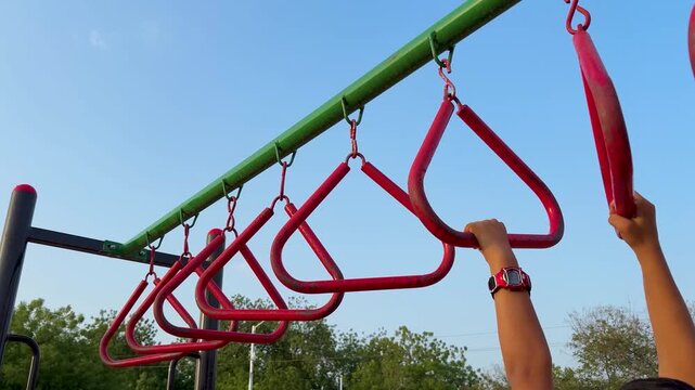 Child Crossing Monkey Bars On Outdoor Adventure Playground In Evening Light