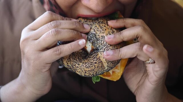 Eating a bagel with toppings in a cafe