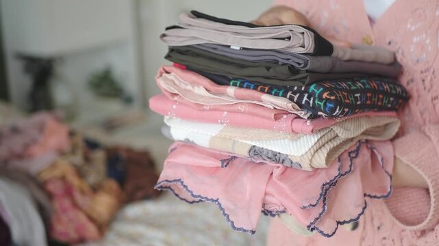 Folding clothes in a bedroom on a Saturday afternoon