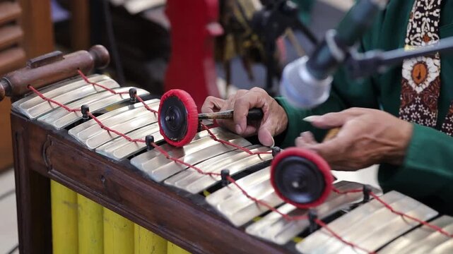 Close up of Indonesian man's hand playing traditional gamelan instrument