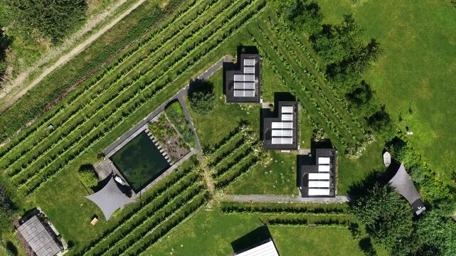 Aerial view of tiny houses in an eco village, showcasing self sufficient living, solar panels, green residential design and a sustainable community setting.