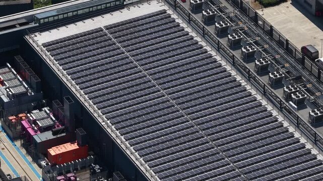 Extensive solar panel arrays covering the rooftop of a modern data center, producing clean, renewable power while advanced cooling systems and backup generators ensure operational efficiency