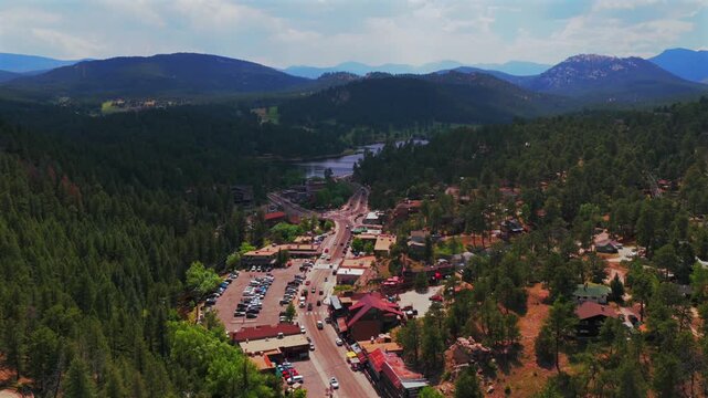Downtown Evergreen Colorado main street business buildings cars Evergreen Lake aerial drone view Denver Golf Course Mt Blue Sky Front Range Rocky Mountain summer spring sunny cloudy morning forward