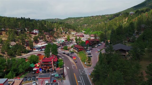 Cactus Jacks downtown Evergreen small mountain town aerial drone view main street business buildings Colorado cars Front Range Rocky Mountains summer spring sunny cloudy morning forward