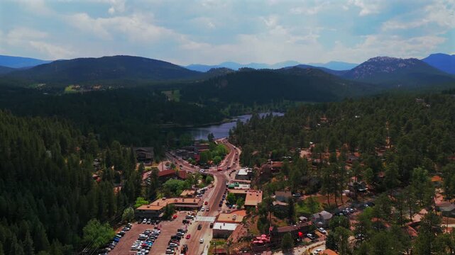 Downtown Evergreen Colorado main street business buildings cars Evergreen Lake aerial drone view Denver Golf Course Mt Blue Sky Front Range Rocky Mountain summer spring sunny cloudy morning backwards