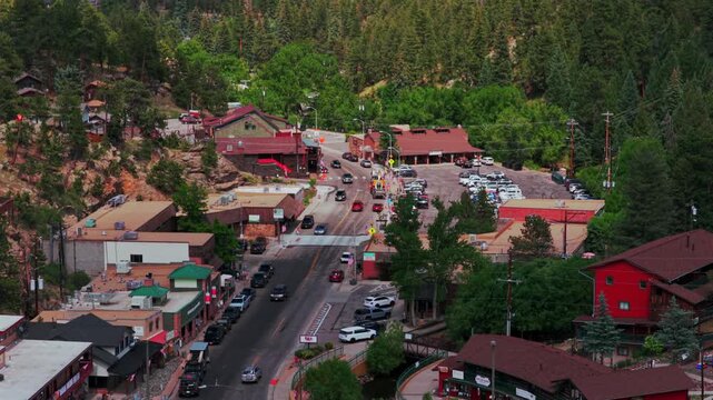 Downtown Evergreen small mountain town close up parallax aerial drone view main street businesses buildings Colorado cars Front Range Rocky Mountains summer spring sunny cloudy morning forward
