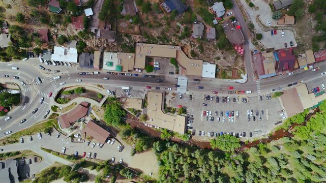 Downtown Evergreen small mountain town aerial drone birdseye view main street business buildings Colorado Upper Bear Creek cars parking lot Front Range Rocky Mountains summer spring sunny morning left