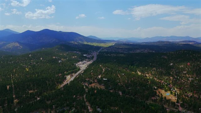 Hiwan Hills Hwy 73 74 downtown Evergreen small mountain town aerial drone view Colorado cars Front Range Rocky Mountains summer spring sunny cloudy morning afternoon open space blue sky forward motion