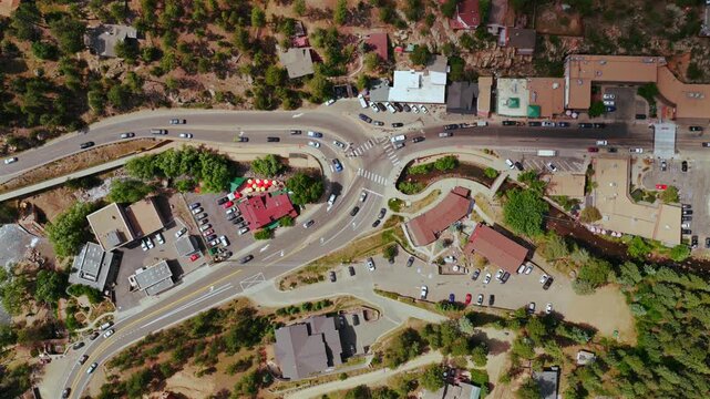 Downtown Evergreen small mountain town aerial drone birdseye main street business buildings Colorado Upper Bear Creek cars parking lot Front Range Rocky Mountains summer spring sunny morning upwards