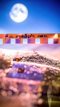 Abstract field with film strip under moon.
