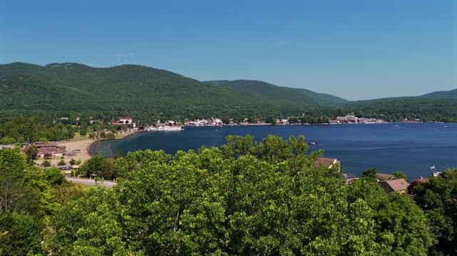 Lake George Million Dollar Beach Park swim beach summer sunny morning blue sky Up State New York aerial drone Town of Lake George landscape Fort William Henry Adirondack Mountains upwards motion