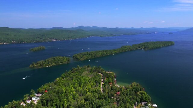 Boating Lake George Long Canoe Speaker Heck Island aerial drone Up State New York Town of Lake George homes landscape harbor view Harris Bay Assembly Point spring summer sunny morning blue sky upwards