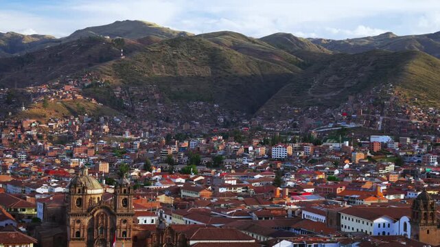 Cusco Plaza de Armas main square city of Cuzco Peru cityscape landscape rainy season sunset golden hour clouds Peruvian neighborhood buildings on mountainside Anta Province Andes static shot