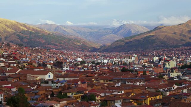 Cusco city of Cuzco Peru cityscape landscape rainy season afternoon sunset golden hour clouds snow-capped Peruvian Andes mountain range neighborhood buildings on mountainside Anta Province zoom in