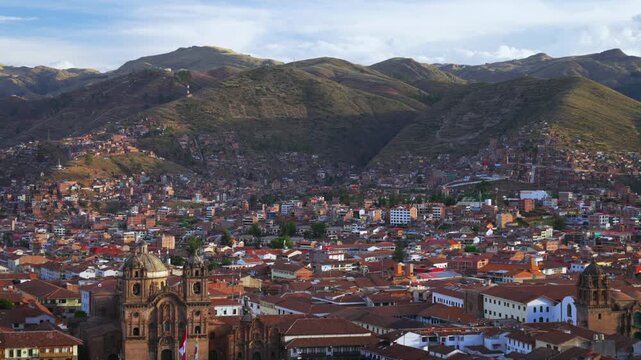 Cusco Cathedral Plaza de Armas main square city of Cuzco Peru cityscape landscape rainy season sunset golden hour clouds Peruvian neighborhood buildings on mountainside Anta Province Andes static shot