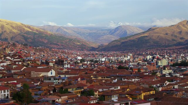 Cusco city of Cuzco Peru cityscape landscape rainy season afternoon sunset golden hour clouds snow-capped Peruvian Andes mountain range neighborhood buildings on mountainside Anta Province static shot