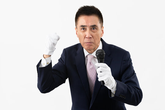 マイクを持ちながら選挙演説をするシニア男性