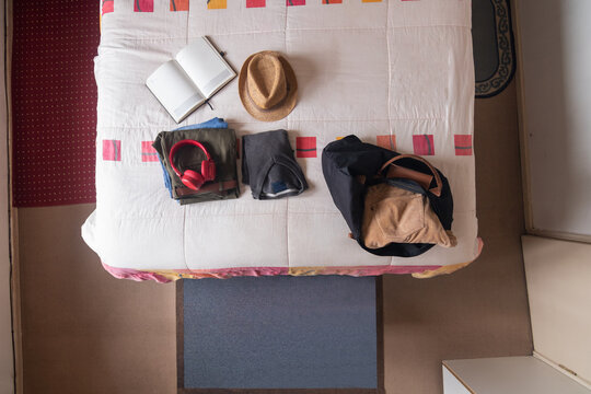 Horizontal high-angle view of packing luggage for a trip in the bedroom