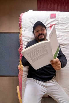 Man reading a open book while lying on bed during a quiet moment at home