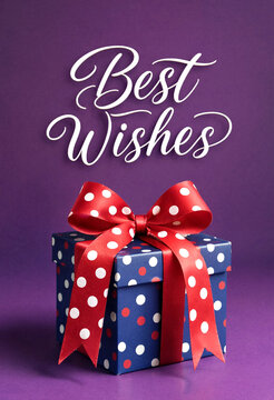 Colorful gift box with red polka dot ribbon and best wishes text on purple background
