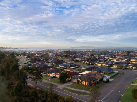 Dawn scene overlooking houses and rooftops of homes along street in Australian suburb