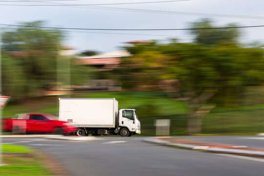 Panning shot capturing motion of truck driving along road transporting goods