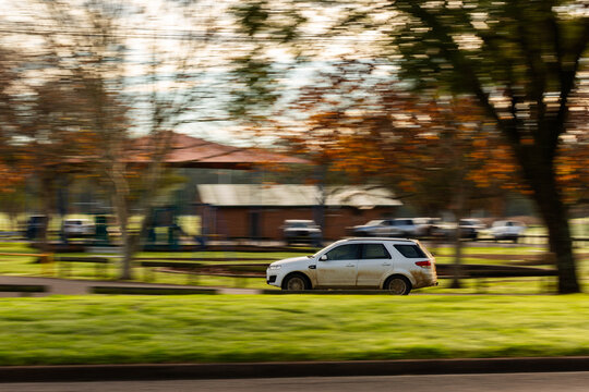 Car on road trip adventure driving into roadside rest stop area with autumn leaves on trees
