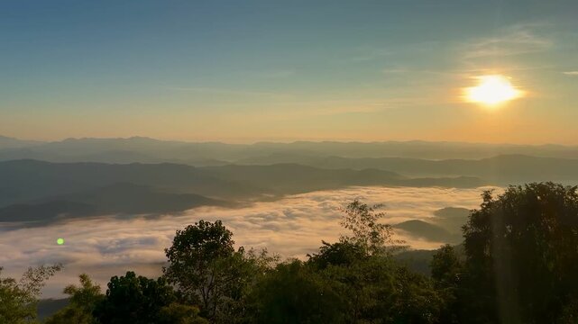 Golden sunrise and a thick sea of mist over mountain ranges at Doi Samer Dao in Nan, Thailand.