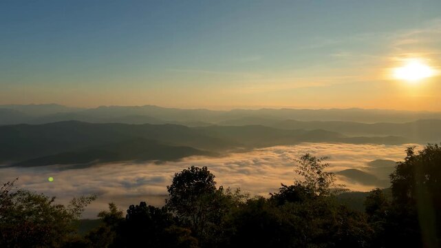 Golden sunrise and a thick sea of mist over mountain ranges at Doi Samer Dao in Nan, Thailand.