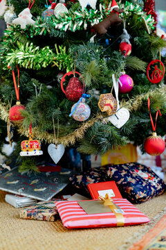 Christmas presents lying under the decorated Christmas tree inside home