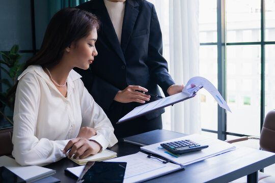 Asian boss businesswoman teaching intern work with document