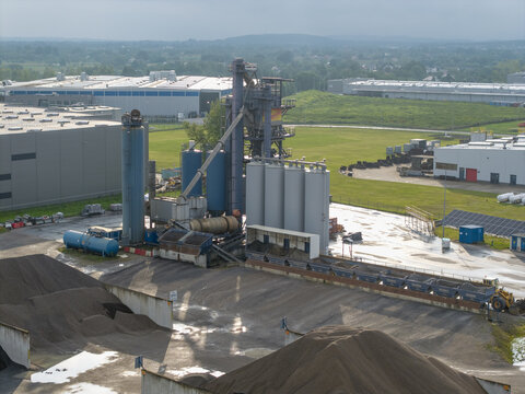 Skawina, Lesser Poland Voivode, Poland - 19 July 2026: Aerial view of the Colas asphalt plant, featuring industrial silos, storage tanks, and aggregate piles.