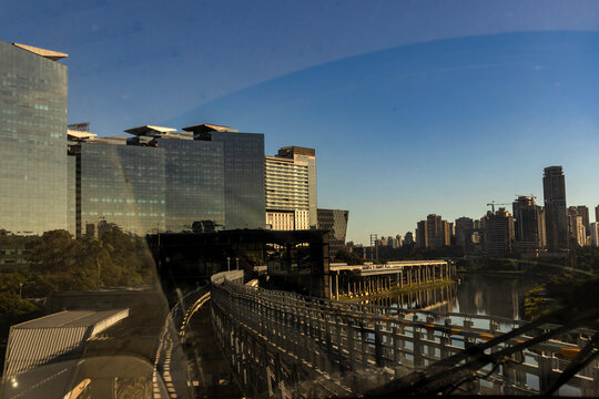 View from a train window showing the modern architecture of the corporate financial district, the concrete tracks of the Line 17 Gold monorail system in Sao Paulo,