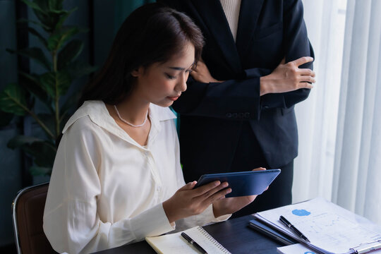 Asian boss businesswoman teaching intern working on tablet