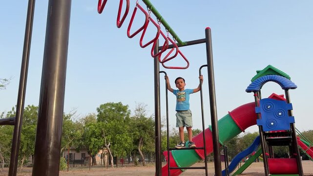 Happy Child Climbing Monkey Bars In Public Park Adventure Playground Activity